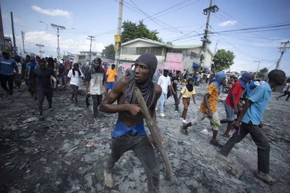 A protester carries a piece of wood simulating a weapon during a protest demanding the resignation of Prime Minister Ariel Henry, in the Petion-Ville area of Port-au-Prince, Haiti. (Odelyn Josephs/AP)