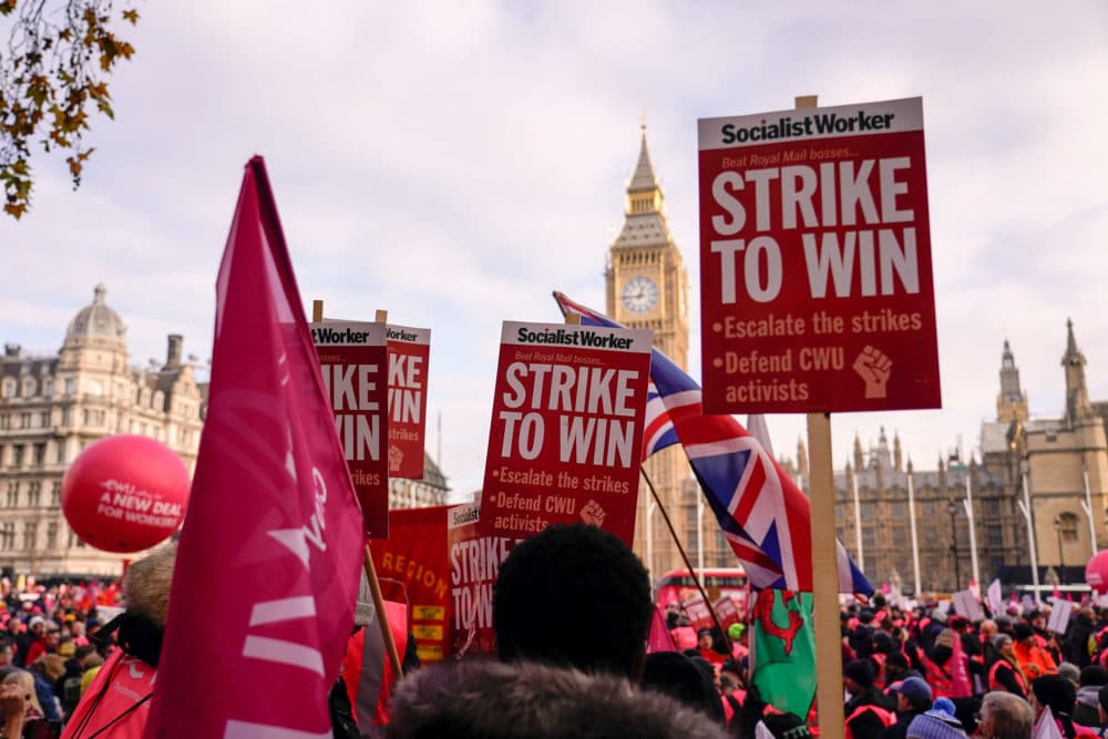 Royal Mail workers hold placards and banners as they gather in Parliament Square, to hold a protest over pay and jobs. (Alberto Pezzali/AP)