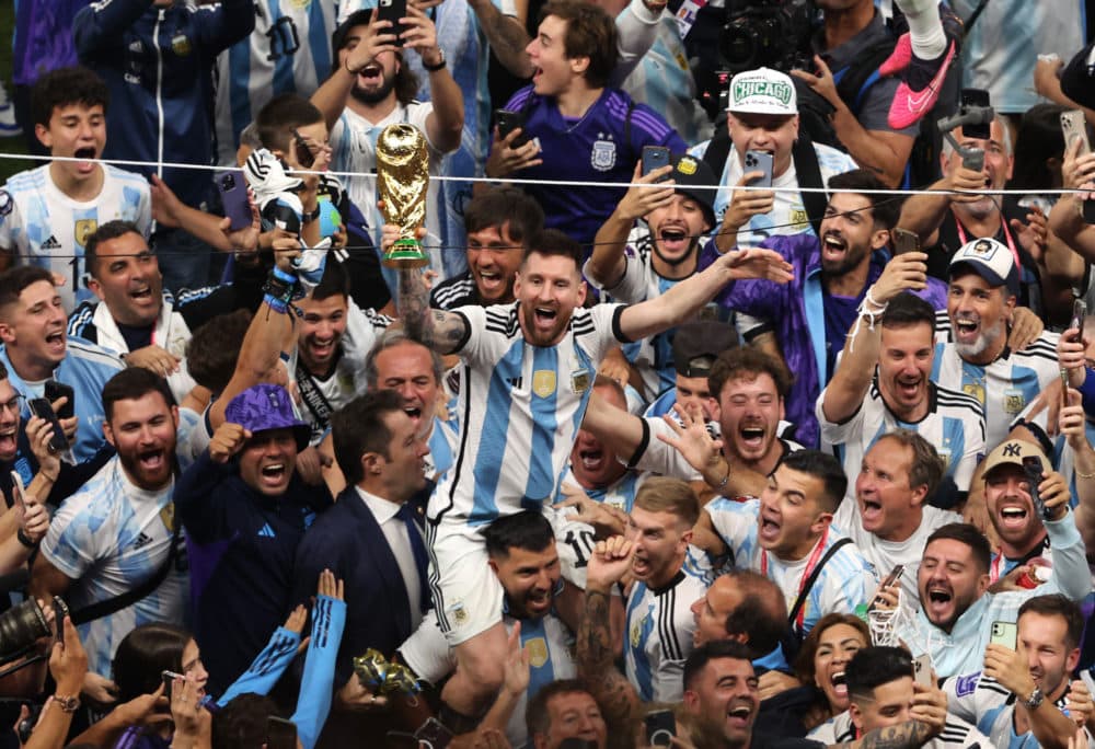 Lionel Messi of Argentina celebrates with the world cup trophy following his sides victory during the FIFA World Cup Qatar 2022 Final match between Argentina and France at Lusail Stadium on Dec. 18, 2022 in Lusail City, Qatar. (Alex Pantling/Getty Images)
