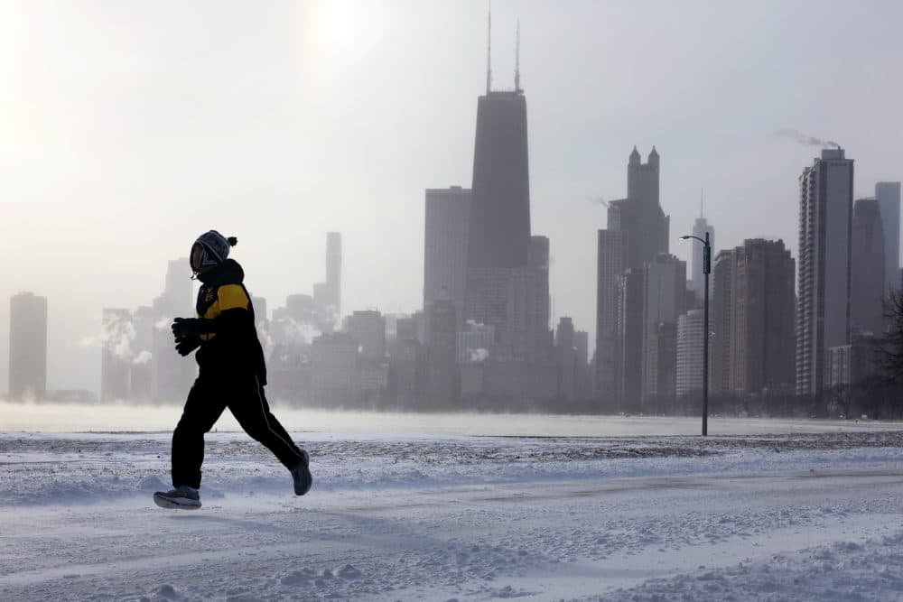 A jogger runs along Lake Michigan at sunrise as temperatures hover about -8 degrees on Dec. 22, 2022 in Chicago, Illinois. Sub-zero temperatures are expected to grip the city for the next couple of days with wind chill temperature dipping as low as -40 degrees. (Scott Olson/Getty Images)