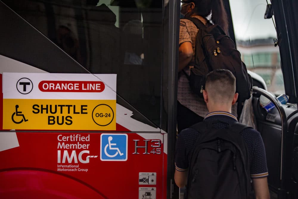 Commuters board an Orange Line shuttle bus at Sullivan Station during the month-long shutdown in August 2022. (Jesse Costa/WBUR)