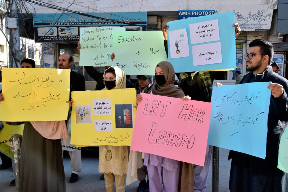 Afghan university students chant slogans and hold placards during a protest against the ban on university education for women. (Arshad Butt/AP)