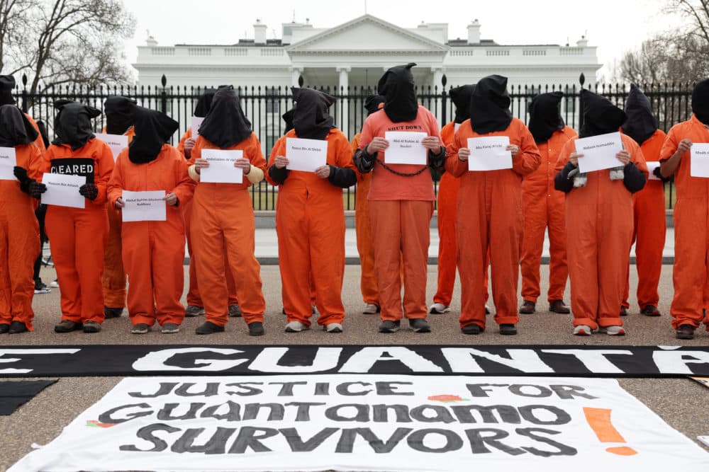 Activists in orange jumpsuits, representing the 35 men who are still being held at the U.S. detention facility in Guantanamo Bay, Cuba, participate in a protest in front of the White House on Jan. 11, 2023 at Lafayette Square in Washington, D.C. (Alex Wong/Getty Images)