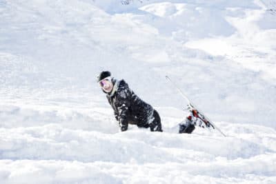 Skier kneeling in the snow on a ski slope. (Getty Images)
