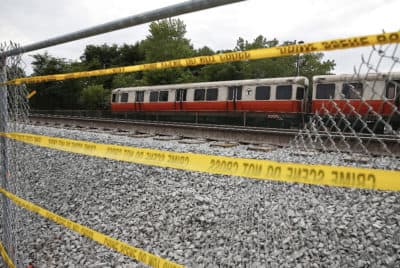 Police tape hangs across a hole cut in a fence to help evacuate Orange Line passengers due to a fire in Medford in August of 2019.(Matthew J. Lee/The Boston Globe via Getty Images)