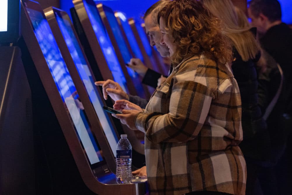 Guests place the first sports bets at the WynnBET Kiosk Room at Encore Boston. (Jesse Costa/WBUR)