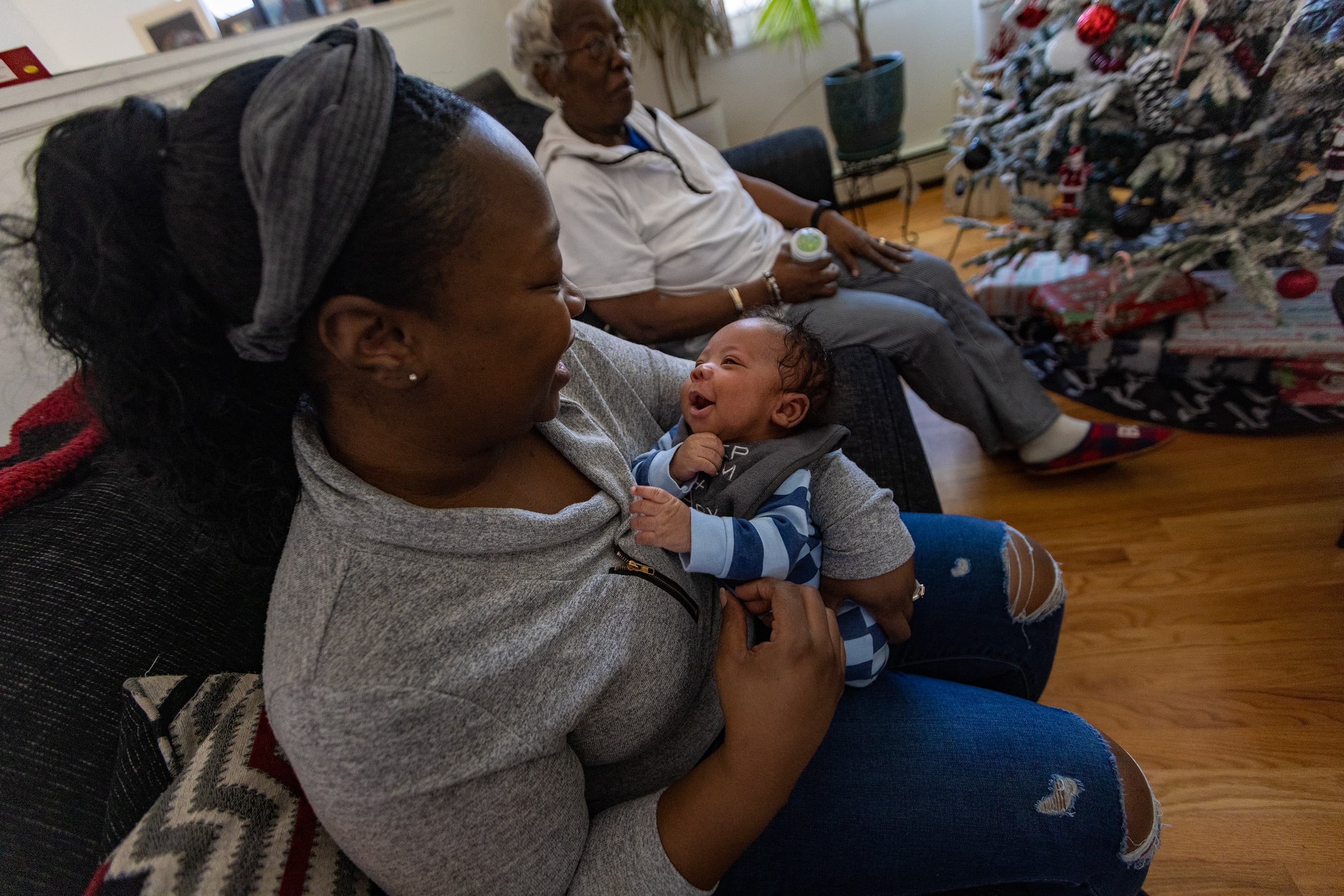 Kennise Nevers holds AJ in her arms at home. (Jesse Costa/WBUR)