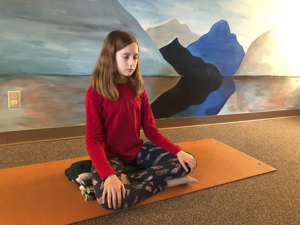 Aeva Schifferli, 12, demonstrates a stress-relieving breathing exercise at her mother's yoga studio. (Carolyn Thompson/AP)