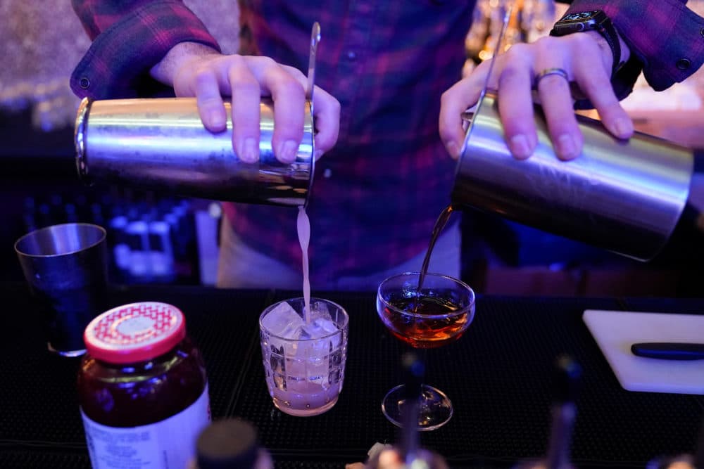 A mixologist pours two mixed drinks. (Julio Cortez/AP)