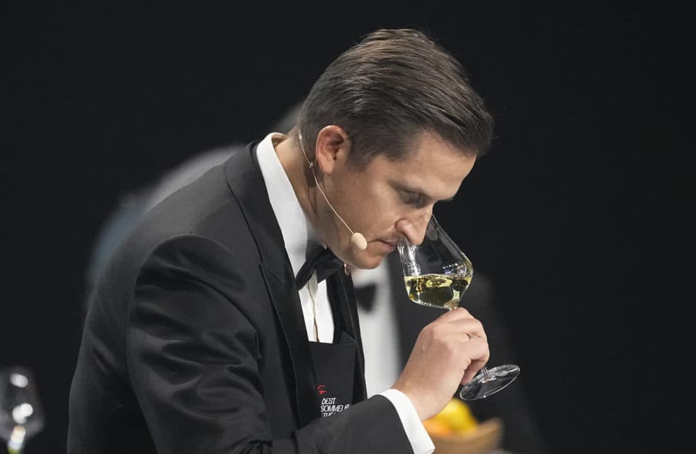 Raimonds Tomsons of Latvia, smells at a glass of white wine during the Best Sommelier of the World in Paris, Sunday, Feb. 12, 2023. Raimonds Tomsons finished first ahead of Nina Jensen of Denmark and Reeze Choi of China. (Michel Euler/AP)