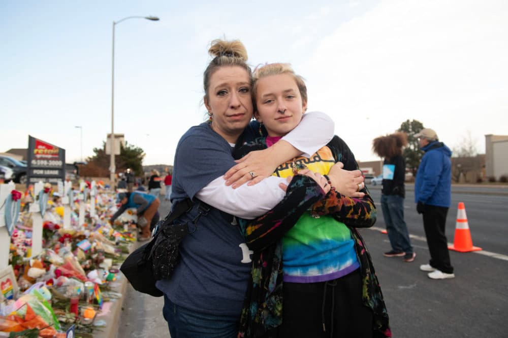 Layla Aronow poses with child Kai Aronow, 12, who is transgender, at the memorial near Club Q in Colorado Springs, United States on Nov. 23, 2022. While posing for the photograph, someone in a passing car yelled out, &quot;Faggot!&quot; Kai calmly stated after, &quot;It definitely hurts, but it doesn't have the power they want it to have. I'm just glad there are so many people who care.&quot; (Ross Taylor for The Washington Post via Getty Images)