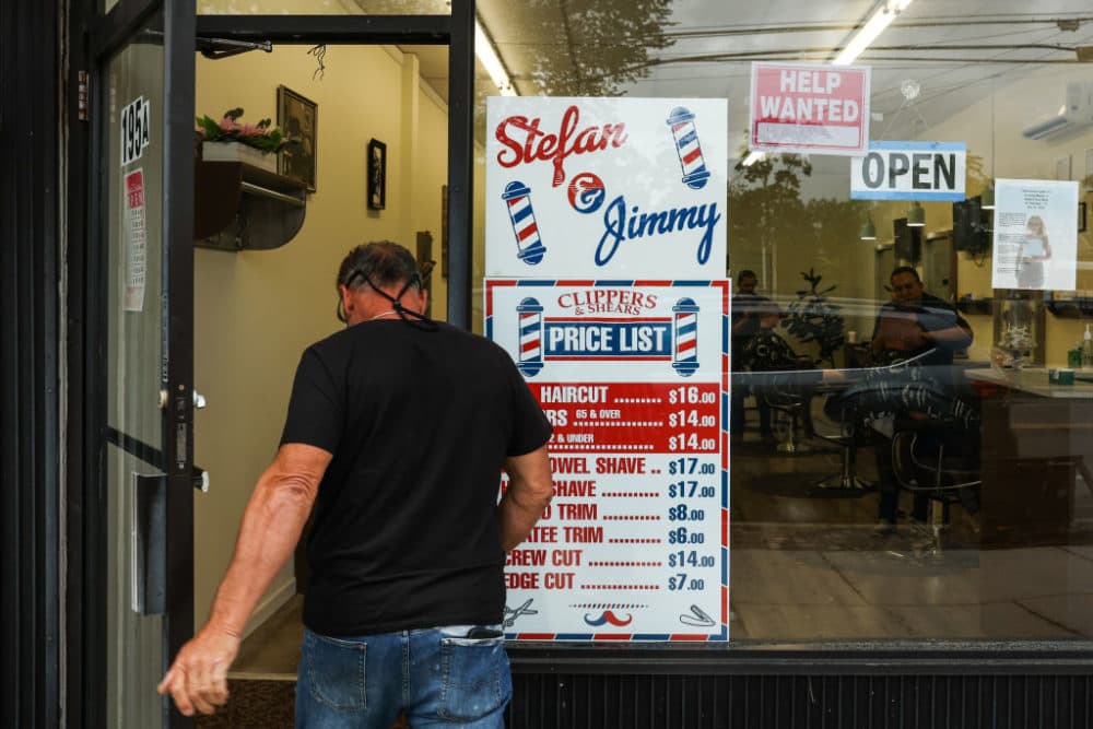 A customer walks into Clippers and Shears barber shop in Sayville, New York, to get a haircut on June 22, 2022. Co-owner Jimmy Riahi is looking to fill an empty chair by hiring at least one extra barber. (Photo by Steve Pfost/Newsday RM via Getty Images)