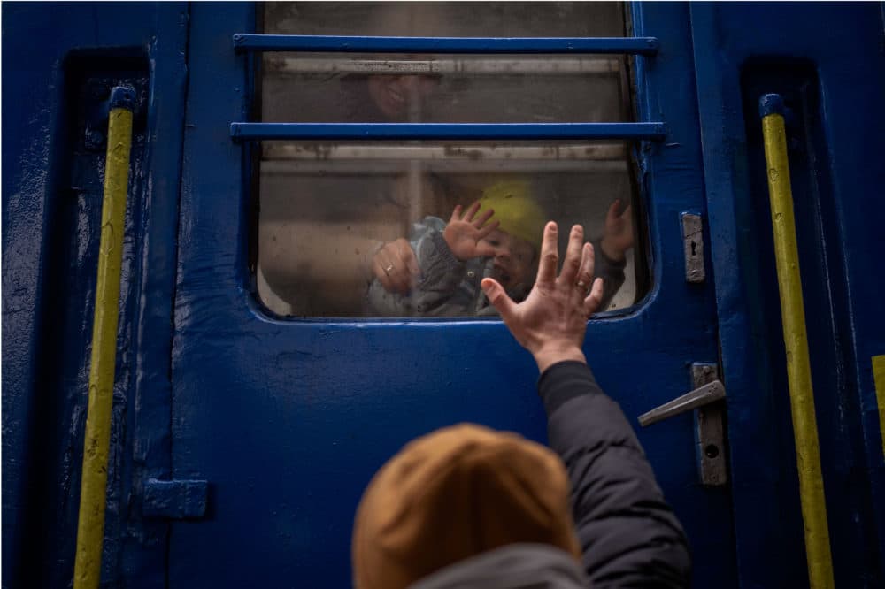 A man says goodbye to his 2-year-old son and wife after they boarded a train that will take them to Lviv, from the station in Kyiv, Ukraine, Thursday, March 3. 2022. He stayed to fight as his family sought refuge in a neighboring country. (Emilio Morenatti/AP)