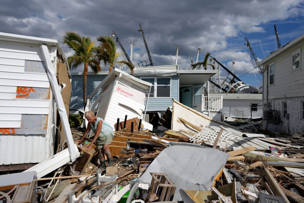 A homeowner picks through debris from destroyed trailers in the mobile home park where she had a winter home on San Carlos Island in Fort Myers Beach, Fla., Oct. 5, 2022, one week after the passage of Hurricane Ian. (Rebecca Blackwell/AP)