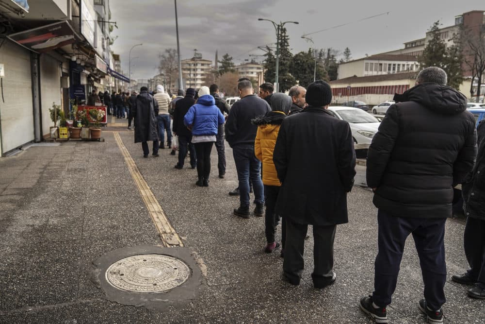 People stand in queue as they wait to buy bread from a bakery in Gaziantep, southeastern Turkey on Feb. 7. (Mustafa Karali/AP)