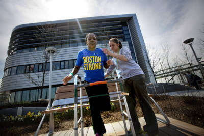 Mery Daniel, pictured above at the Spaulding Rehabilitation Hospital with occupational therapist Becky Buttiglieri, had part of her left leg amputated after the bombing. (Jesse Costa/WBUR)
