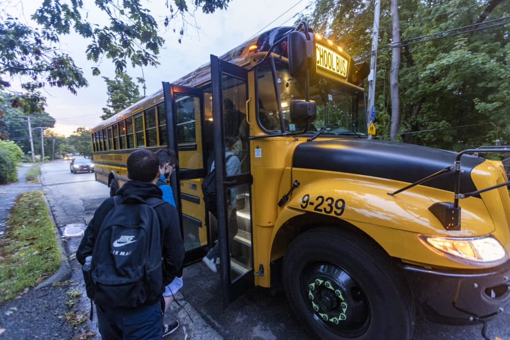 Students from Worcester Technical High School climb aboard a school bus. (Jesse Costa/WBUR)