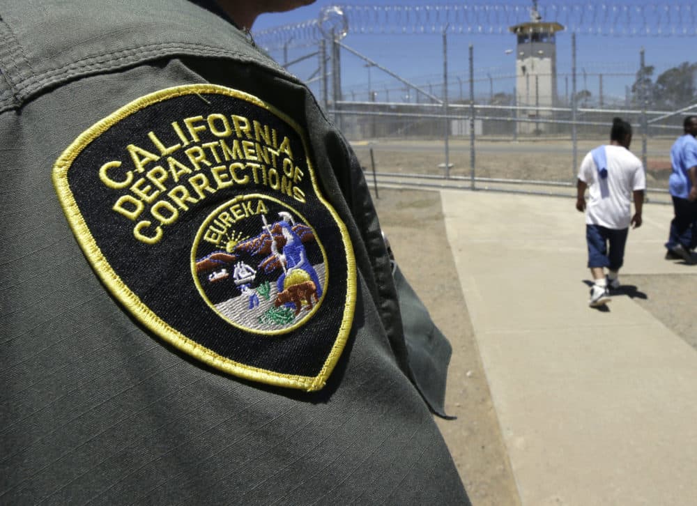 Inmates pass a correctional officer as they leave an exercise yard. (Rich Pedroncelli/AP)