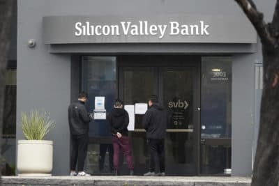 People look at signs posted outside of an entrance to Silicon Valley Bank in Santa Clara, Calif., Friday, March 10, 2023. (Jeff Chiu/AP)