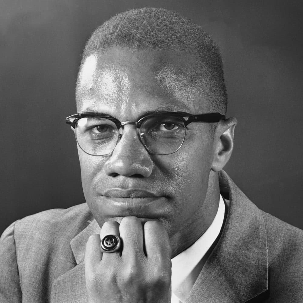 Malcolm X sits for a portrait in London on Feb. 9, 1965, after he was refused entry into France. (Victor Boynton/AP)