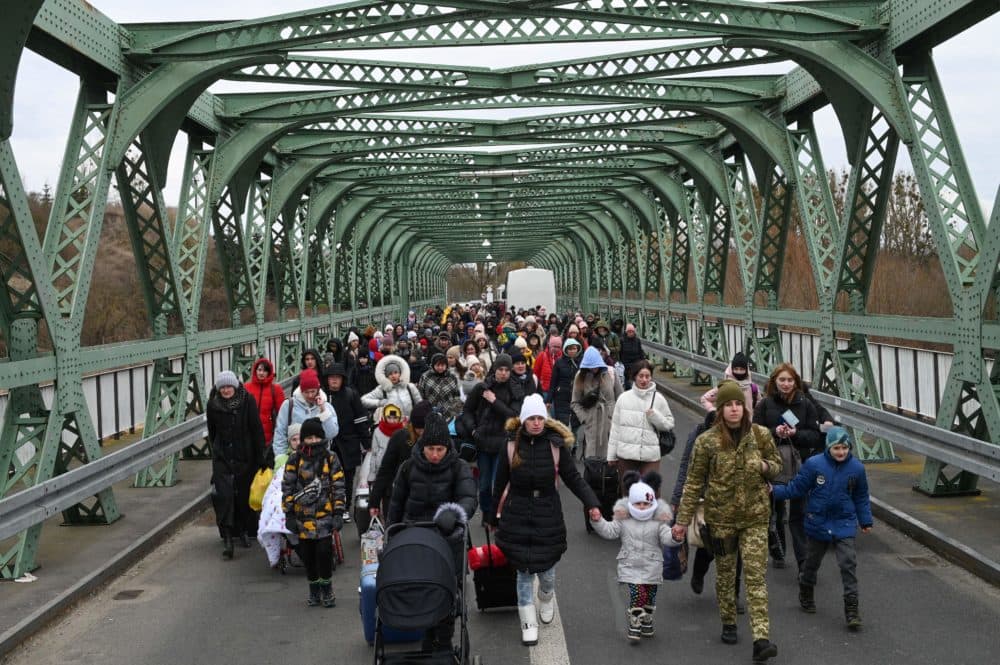 Ukrainian refugees walk a bridge at the buffer zone with the border with Poland in the border crossing of Zosin-Ustyluh, western Ukraine on March 6, 2022. (Daniel Leal/AFP via Getty Images)