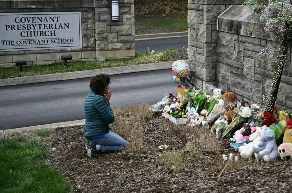 A woman prays at a makeshift memorial for victims outside the Covenant School building at the Covenant Presbyterian Church following a shooting, in Nashville, Tennessee, on March 28, 2023. A heavily armed former student killed three young children and three staff in what appeared to be a carefully planned attack at a private elementary school in Nashville on March 27, before being shot dead by police. (Brendan Smialowski/AFP via Getty Images)