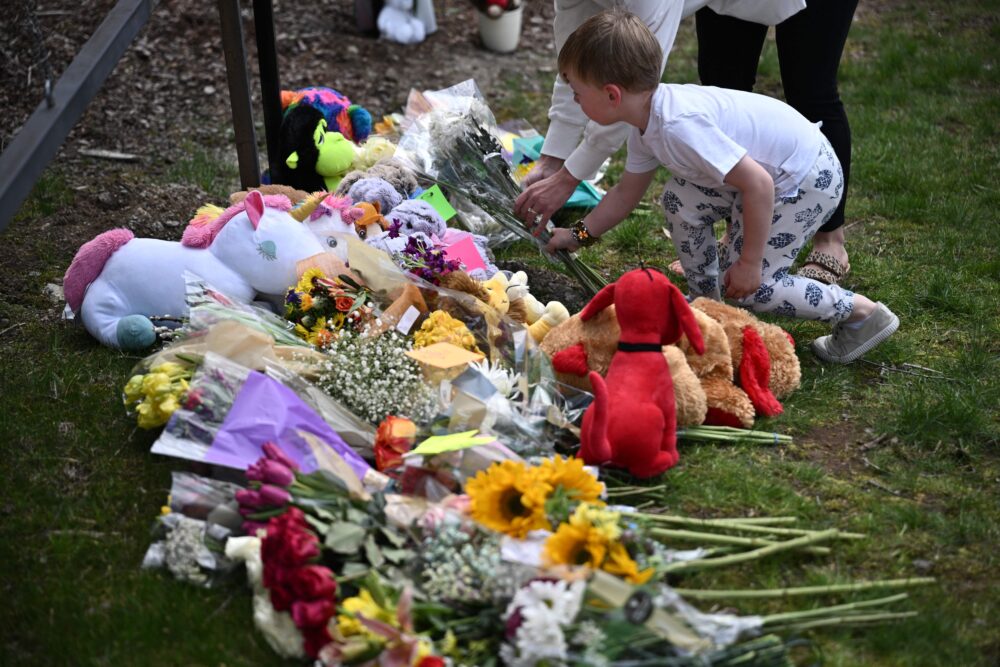 A boy leaves flowers at a makeshift memorial for victims by the Covenant School building at the Covenant Presbyterian Church following a shooting, in Nashville, Tennessee, March 28, 2023. (Brendan Smialowski/AFP via Getty Images)