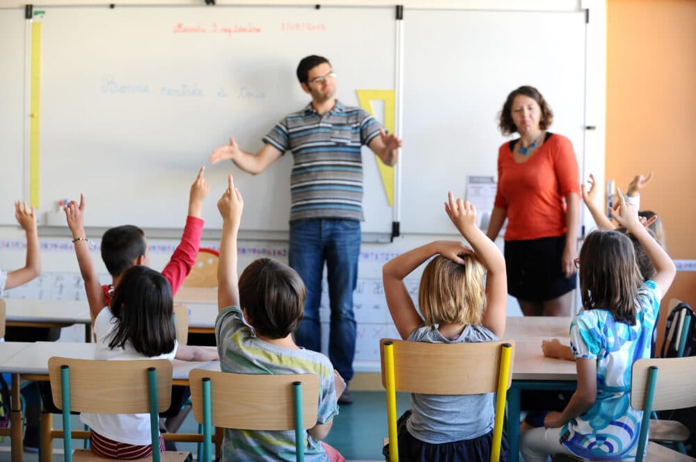 A teacher uses sign language (Remy Gabalda/AFP via Getty Images)