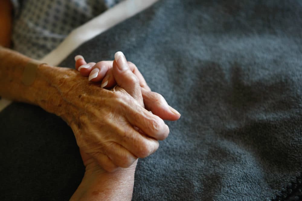 A terminally-ill resident of the Hospice of Saint John is comforted in her bed. (John Moore/Getty Images)