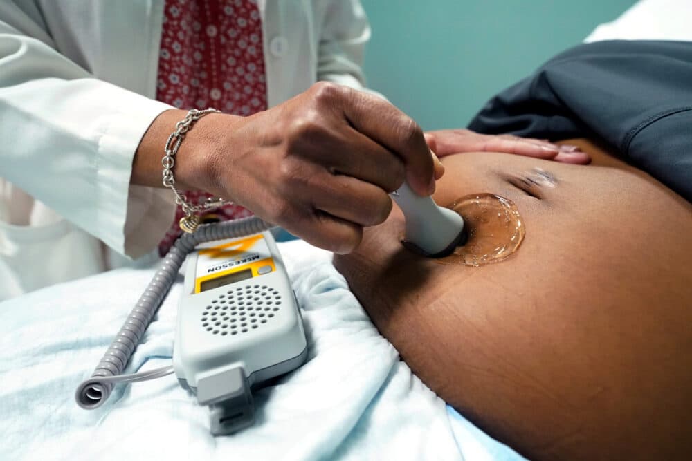 A doctor uses a hand-held Doppler probe on a pregnant woman to measure the heartbeat of the fetus. (Rogelio V. Solis/AP)