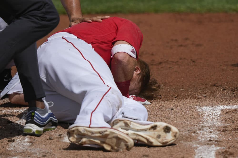 Boston Red Sox Justin Turner rolls on the ground after being hit in the face on a pitch by Detroit Tigers starting pitcher Matt Manning in the first inning of their spring training baseball game in Fort Myers, Fla., March 6. (Gerald Herbert/AP)
