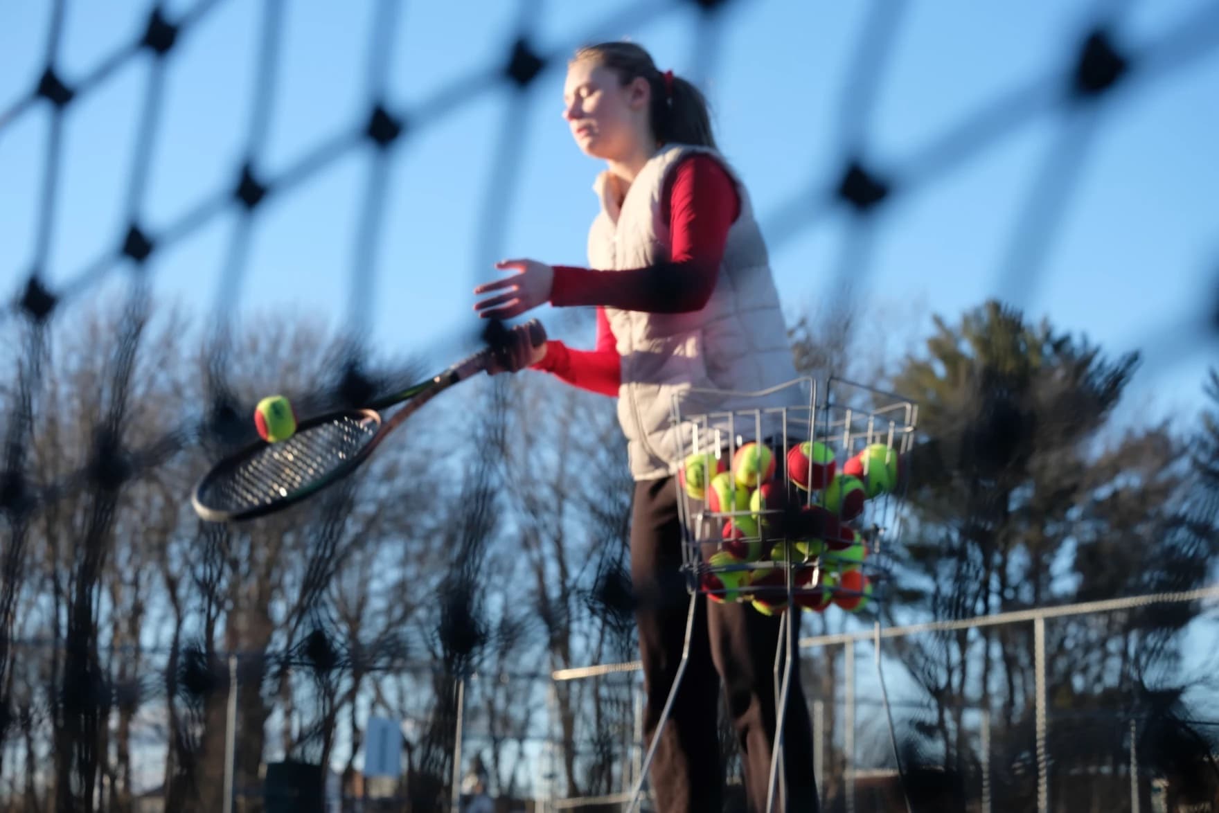 A photo of tennis player Polina Makarenko bouncing a tennis ball on her racket. (Todd Bookman/NHPR)