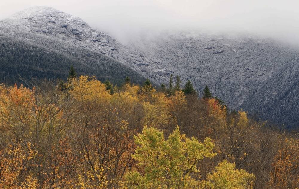 Morning clouds lift off the snow covered summit of Mount Lafayette as the sun hits the colorful leaves, Thursday, Oct. 11, 2012 in Franconia, N.H. Officials said Emily Sotelo died when she was caught unprepared in harsh conditions during a hike in November 2022. (Jim Cole/AP)