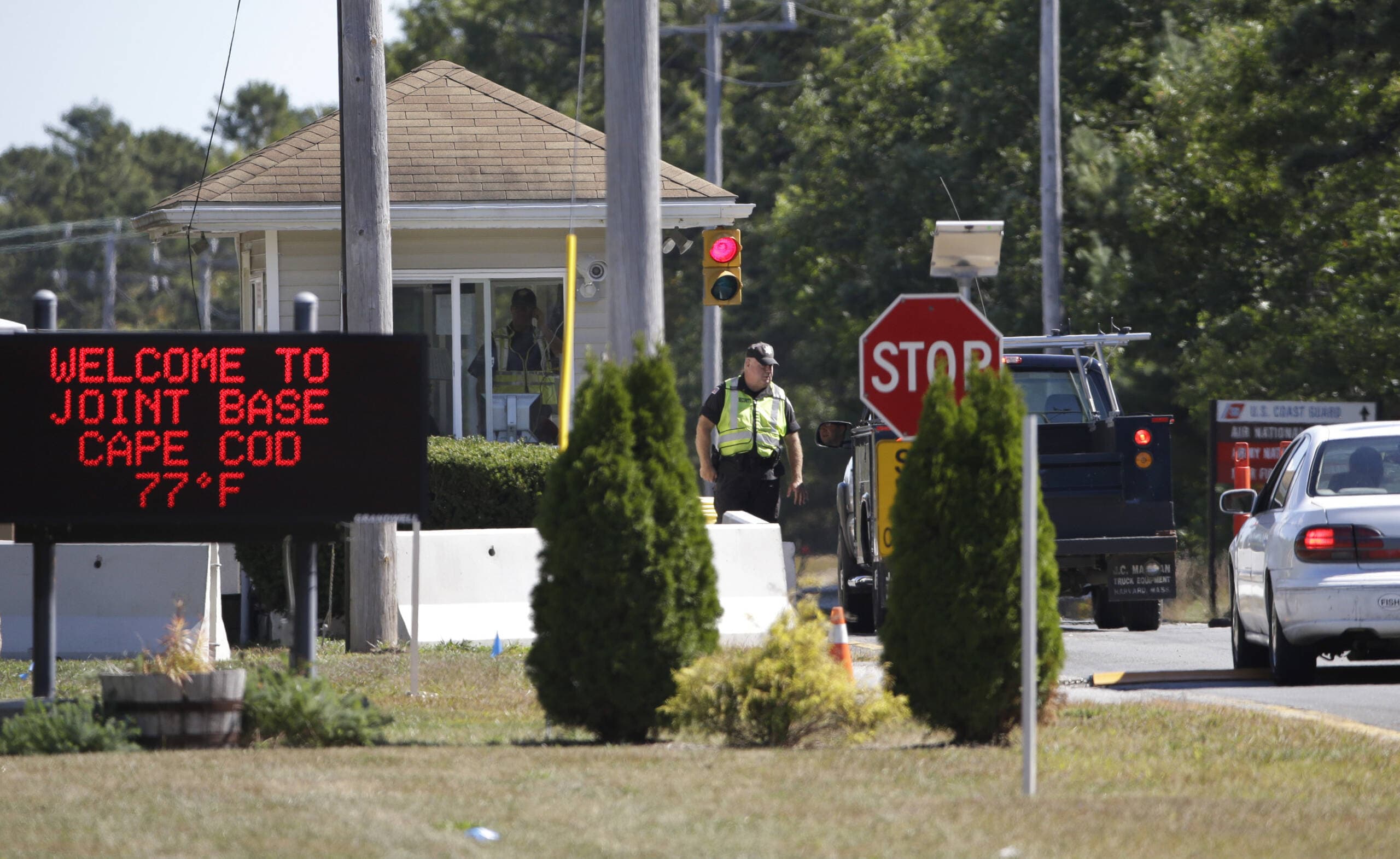 Vehicles are stopped by security personnel as they enter a gate at Joint Base Cape Cod in 2014. (Steven Senne/AP)