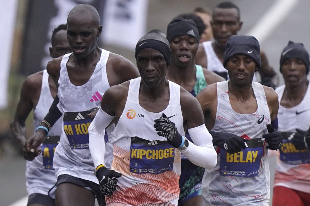 Eliud Kipchoge, of Kenya, center, runs ahead of Andualem Belay, of Ethiopia, second from right, at the front of a group of elite men, along the course of the 127th Boston Marathon, April 17, in Framingham. (Steven Senne/AP)