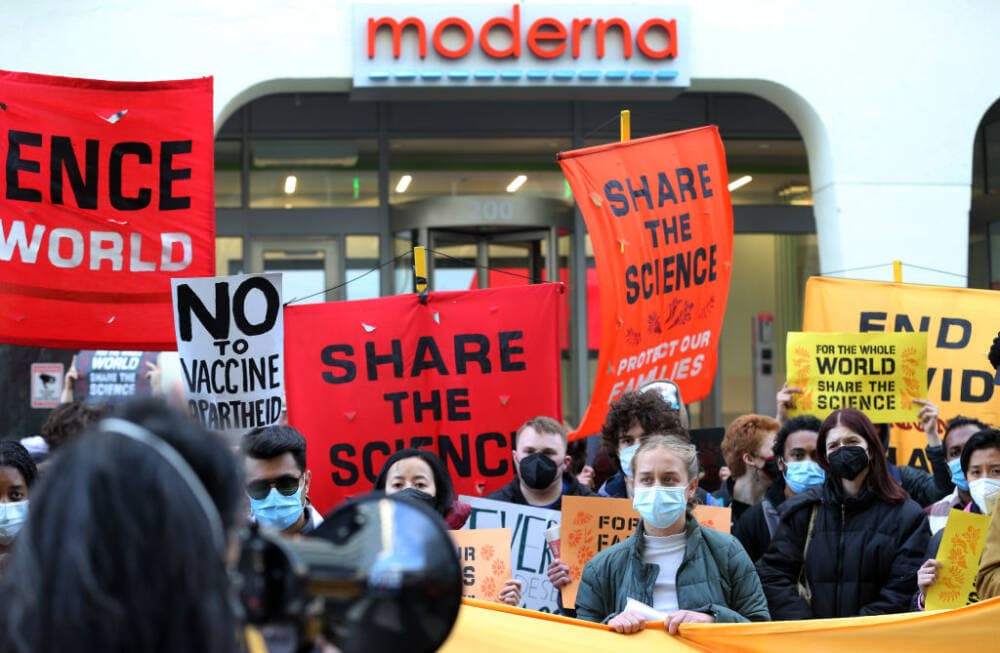 Protestors in front of the Moderna headquarters listen to a speaker during a protest in Cambridge, MA on April 28, 2022.  (Jim Davis/The Boston Globe via Getty Images)