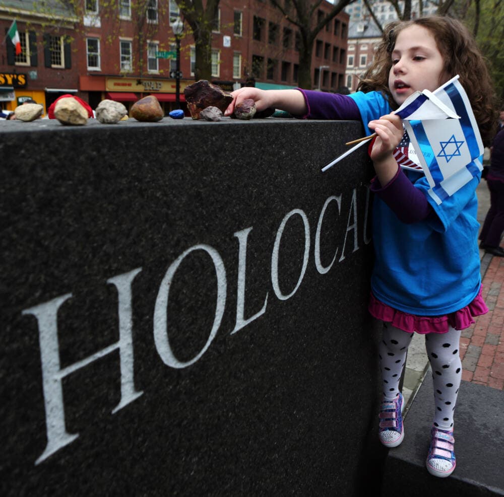 Sophie Einstein examines a rock left at the Boston Holocaust Memorial during the 2016 community Holocaust commemoration of Yom Hashoah. (Angela Rowlings/MediaNews Group/Boston Herald via Getty Images)