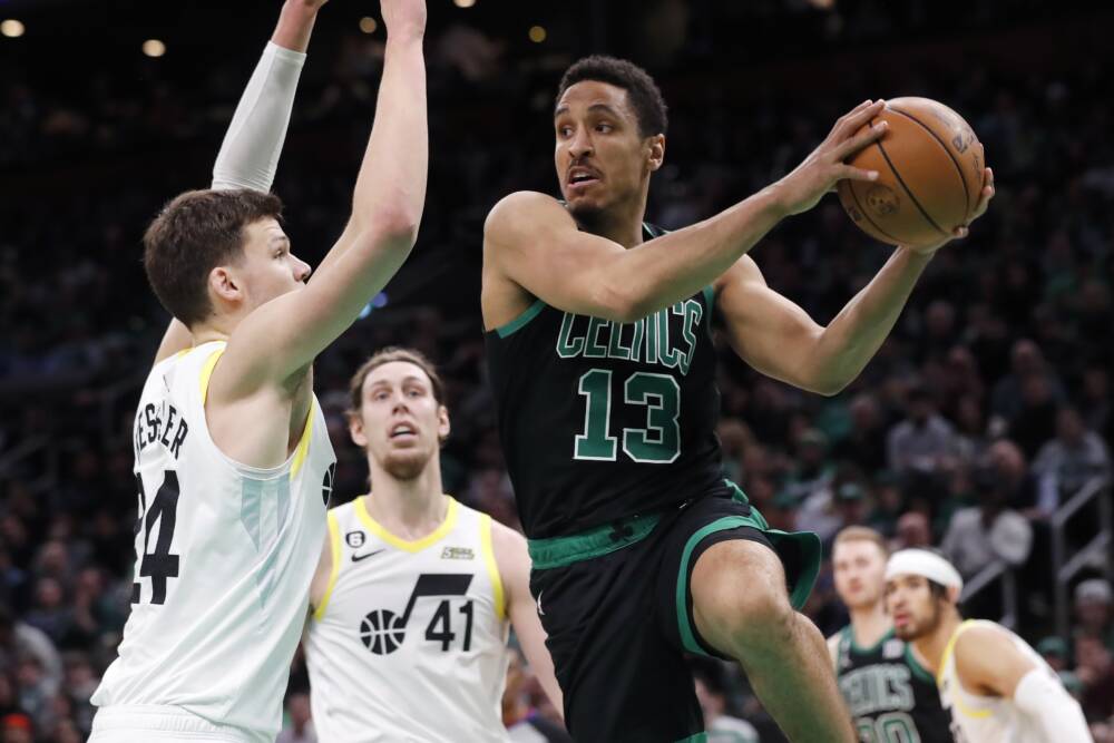 Boston Celtics' Malcolm Brogdon (13) passes the ball against Utah Jazz's Walker Kessler (24) during the second half of an NBA basketball game, March 31, 2023, in Boston. (Michael Dwyer/AP)
