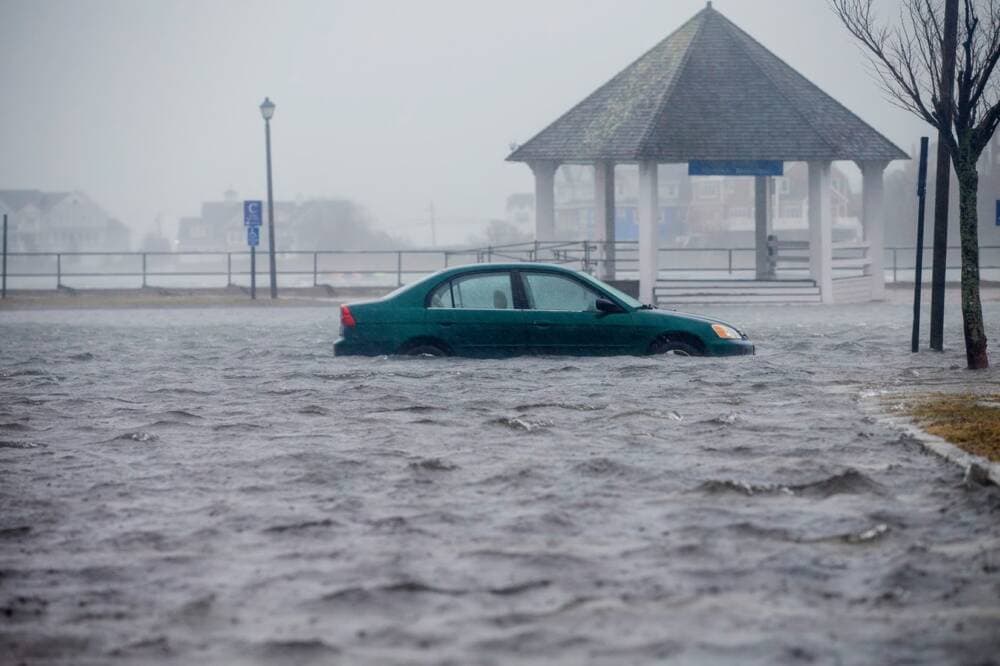 A car sitting in flood water in the parking lot behind the Front St. shops in Scituate, Massachusetts, March 2, 2018. (Jesse Costa/WBUR)