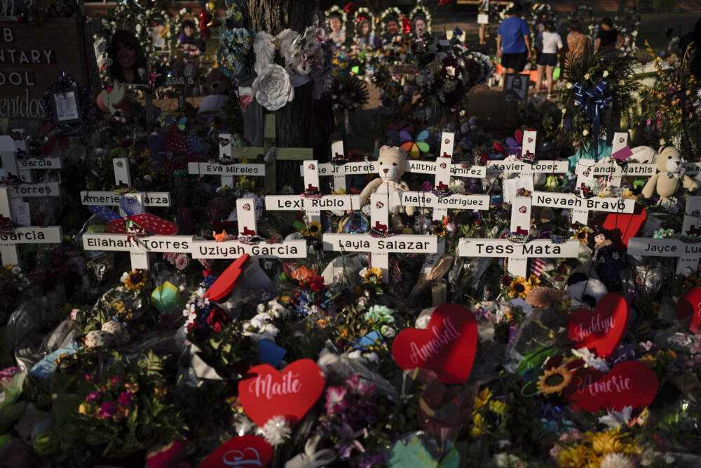 Flowers are piled around crosses with the names of the victims killed in the school shooting at Robb Elementary School. (Jae C. Hong/AP)