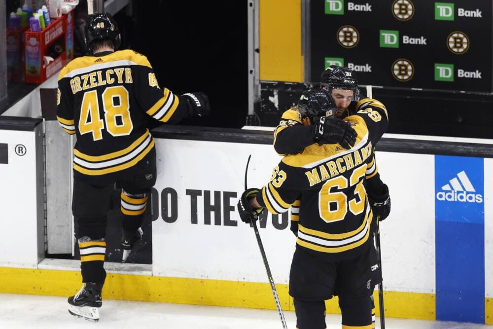 Boston Bruins' Patrice Bergeron (37) hugs Brad Marchand (63) as Matt Grzelcyk (48) walks off the ice after losing to the Florida Panthers in overtime during Game 7 of an NHL hockey Stanley Cup first-round playoff series. (Michael Dwyer/AP)