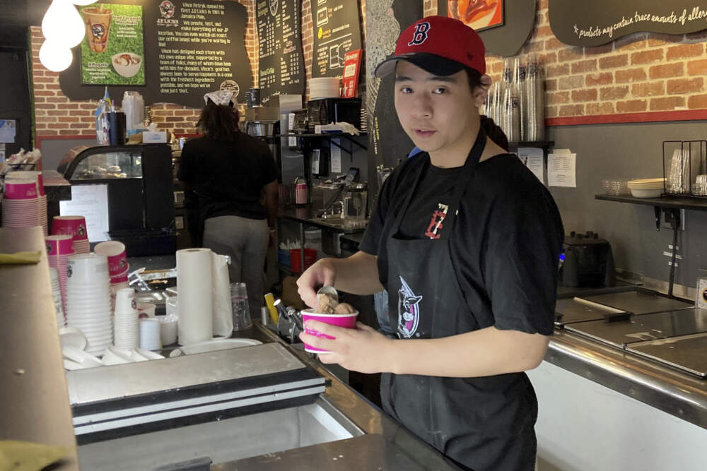 Christopher Au, 19, dishes out ice cream at a J.P. Licks in Boston’s Beacon Hill neighborhood on Thrusday, May 25, 2023. (Steve LeBlanc/AP)