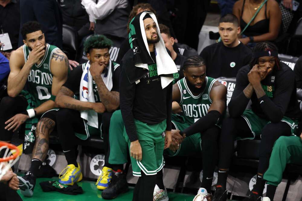 Boston Celtics guard Derrick White, center, stands in front of the bench as his teammates sit behind him in the closing seconds of the second half in Game 7 of the NBA basketball Eastern Conference final. (Michael Dwyer/AP)