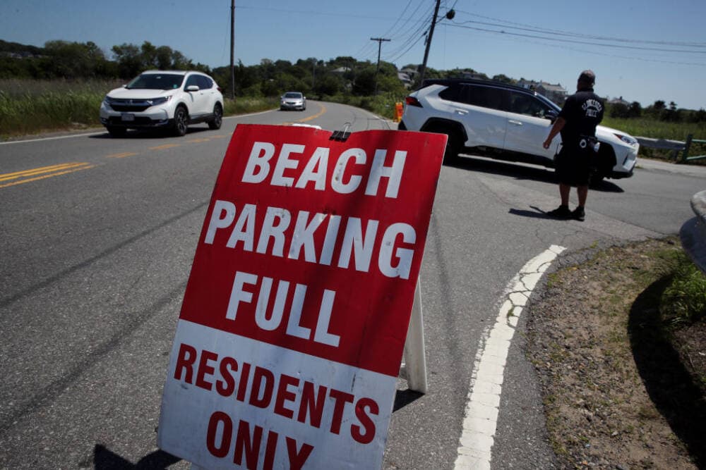 Gloucester police Lieutenant Mike Williams directs traffic at the entrance to Good Harbor Beach in Gloucester on July 18, 2020. (Craig F. Walker/The Boston Globe via Getty Images)