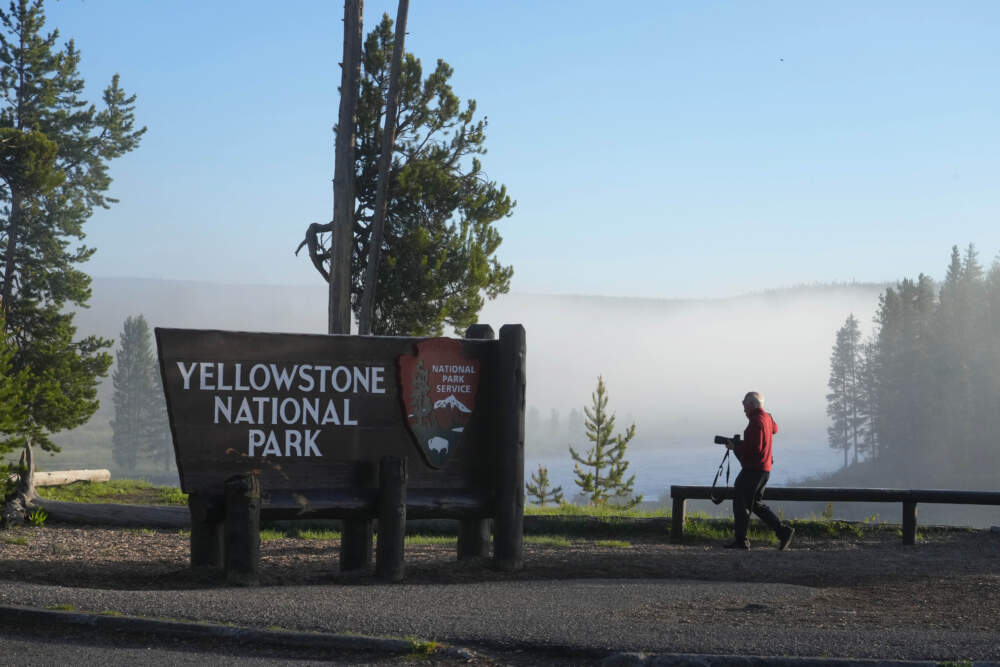 A man takes a picture at the south entrance of Yellowstone National Park, as he waits to gain entry for the first time in more than a week, on June 22, 2022 in Yellowstone National Park, Wyoming. (George Frey/Getty Images)