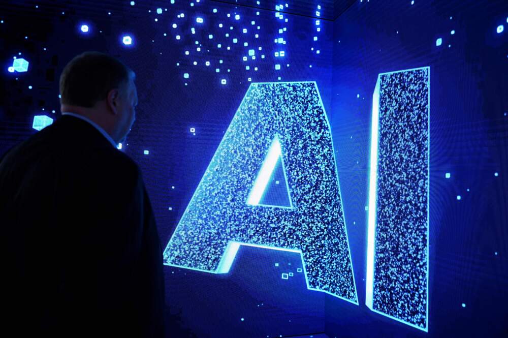 A visitor watches an AI sign. (Josep Lago/AFP via Getty Images)