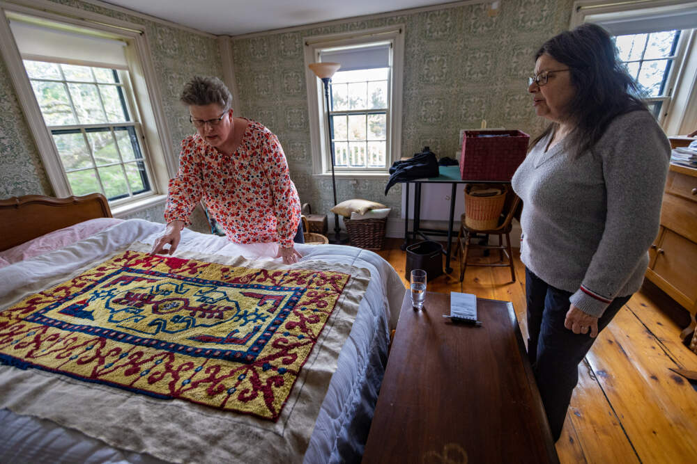 Jan Rohwetter examines the rug Donna Savastio started. (Jesse Costa/WBUR)