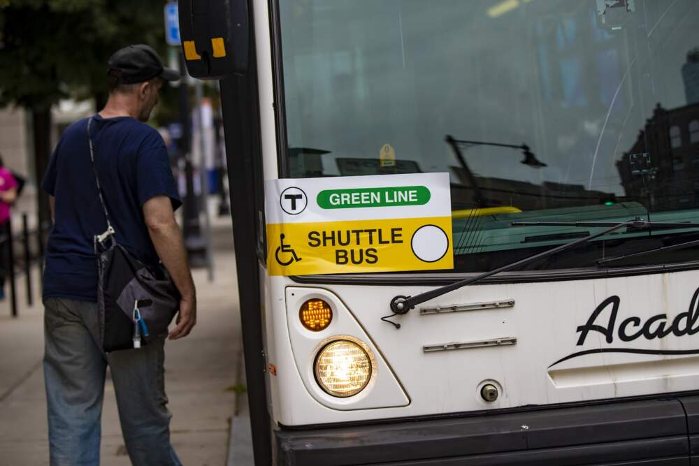 A commuter boards an MBTA Green Line shuttle bus. Shuttle buses will replace Green Line B Branch service for 12 days in July. (Jesse Costa/WBUR)
