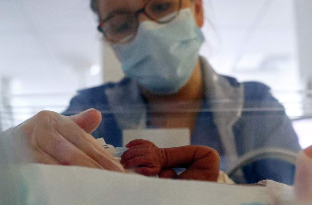 A neonatal nurse cares for a premature baby. (Hannah McKay/POOL/AFP via Getty Images)