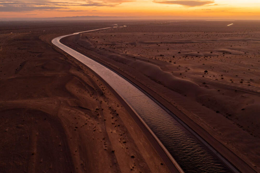 The All-American Canal conveys water through the Imperial Sand Dunes of California's Colorado Desert, a few miles north of the U.S.-Mexico border, on September 28, 2022 near Felicity, California. The 80-mile long canal carries water from the Colorado River to supply nine Southern California cities and 500,000 acres of farmland in the Imperial Valley where a few hundred farms draw more water from the Colorado River than the states of Arizona and Nevada combined.  (David McNew/Getty Images)